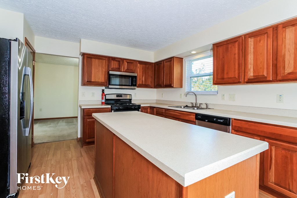 a kitchen with wooden cabinets and a white counter top
