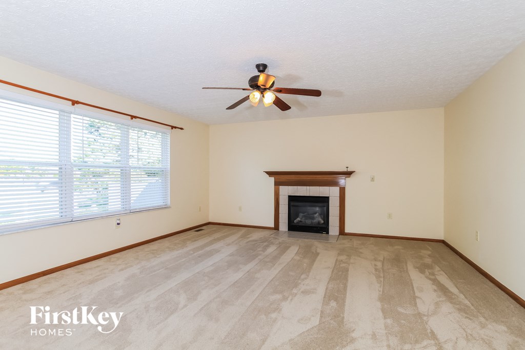 a living room with a fireplace and a ceiling fan