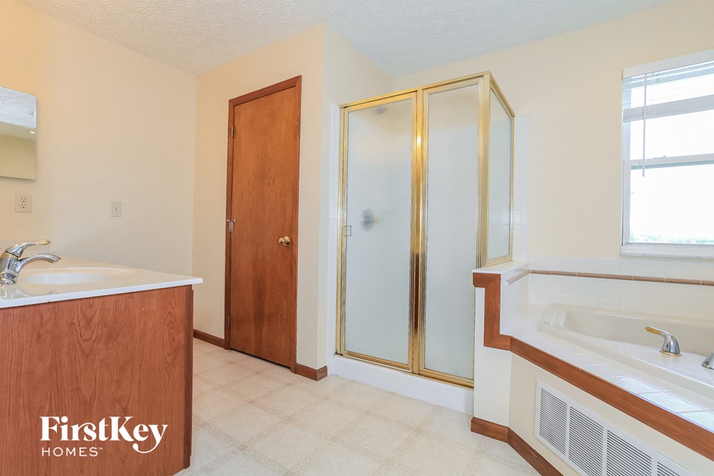 a bathroom with a shower and a sink and a bath tub
