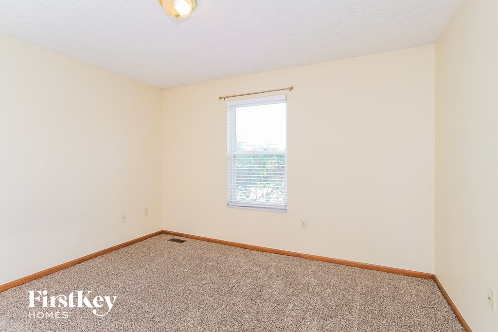 a bedroom with carpet and a window
