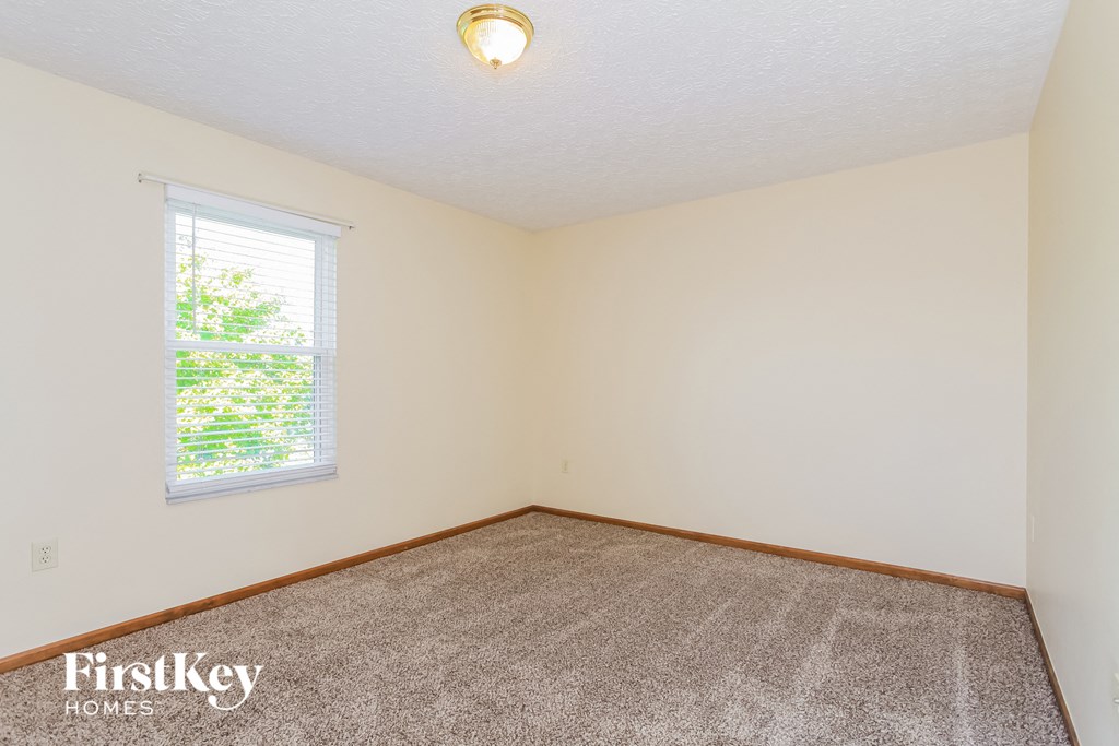 the living room of a home with carpet and a window