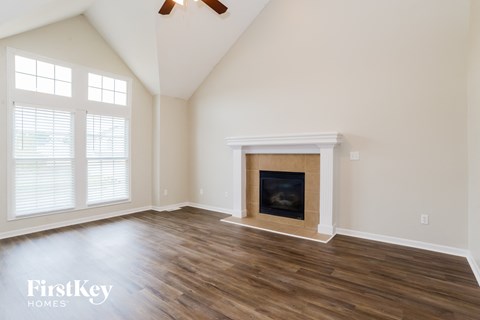 A room with a fireplace and a ceiling fan.
