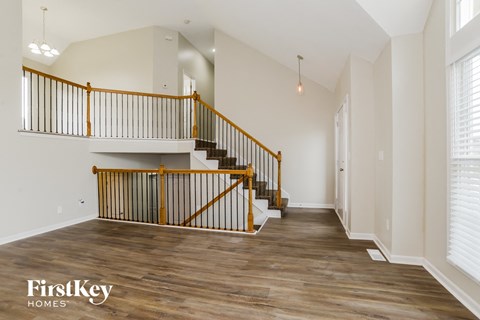 A wooden staircase with a metal railing in a spacious room.