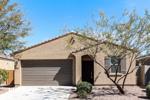 a house with a garage door and a tree