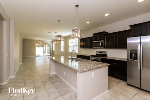 a large kitchen with granite counter tops and black cabinets