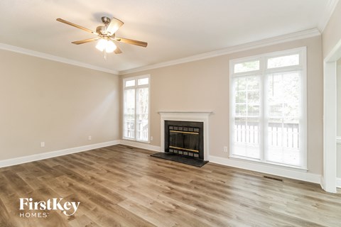 a living room with a fireplace and a ceiling fan