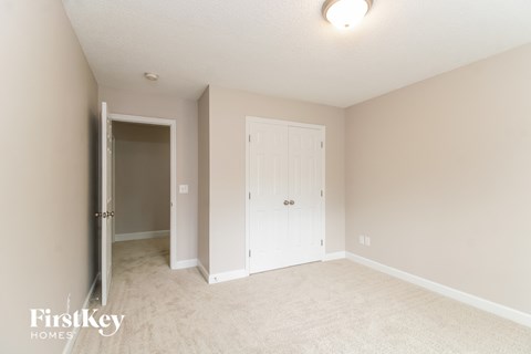 a bedroom with a closet and a door to the bathroom