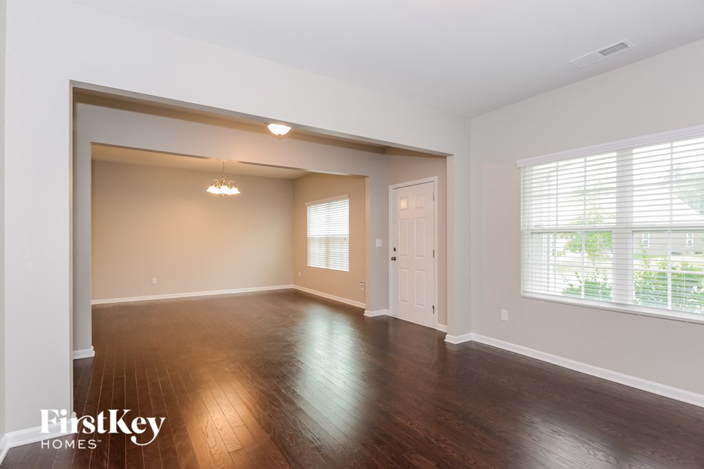 an empty living room with wood floors and a white door