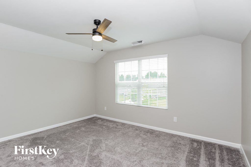 a bedroom with a ceiling fan and a window