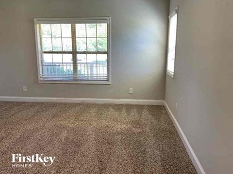 an empty room with carpet and a window
