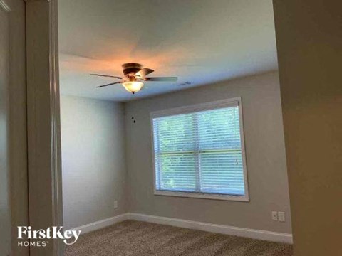 a bedroom with a ceiling fan and a window