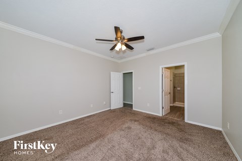 a living room with carpet and a ceiling fan