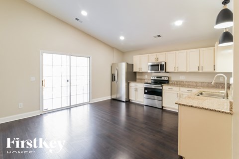 A kitchen with a refrigerator, microwave, and oven.