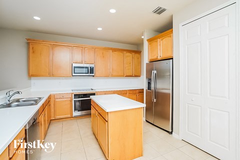 A kitchen with wooden cabinets and a stainless steel refrigerator.