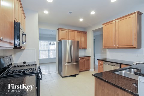 an empty kitchen with wooden cabinets and stainless steel appliances