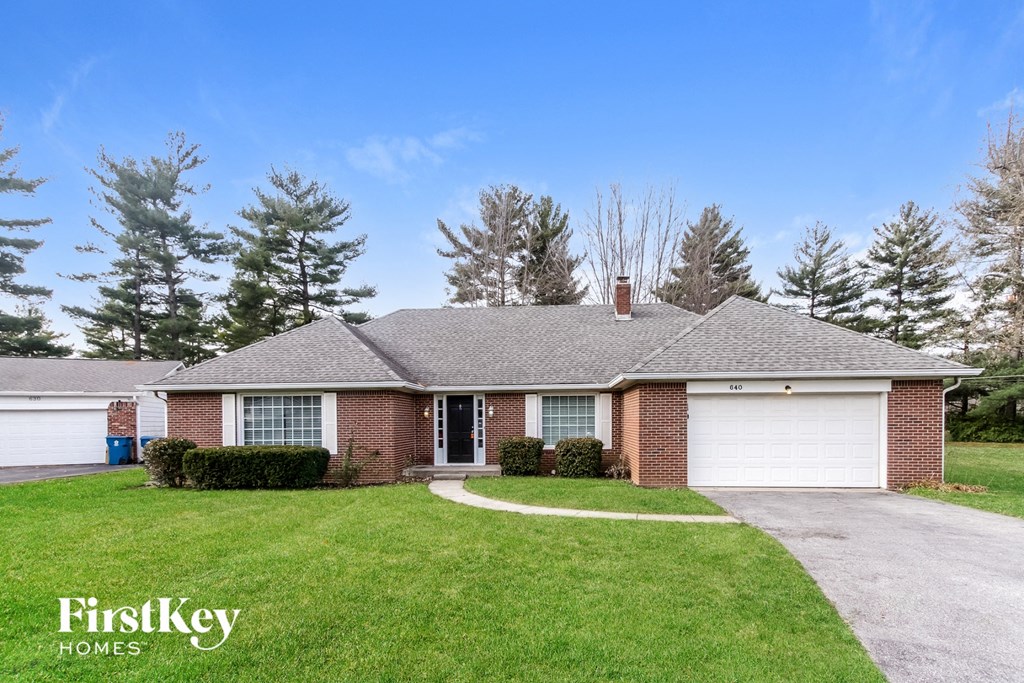 a brick house with a lawn and a white garage door