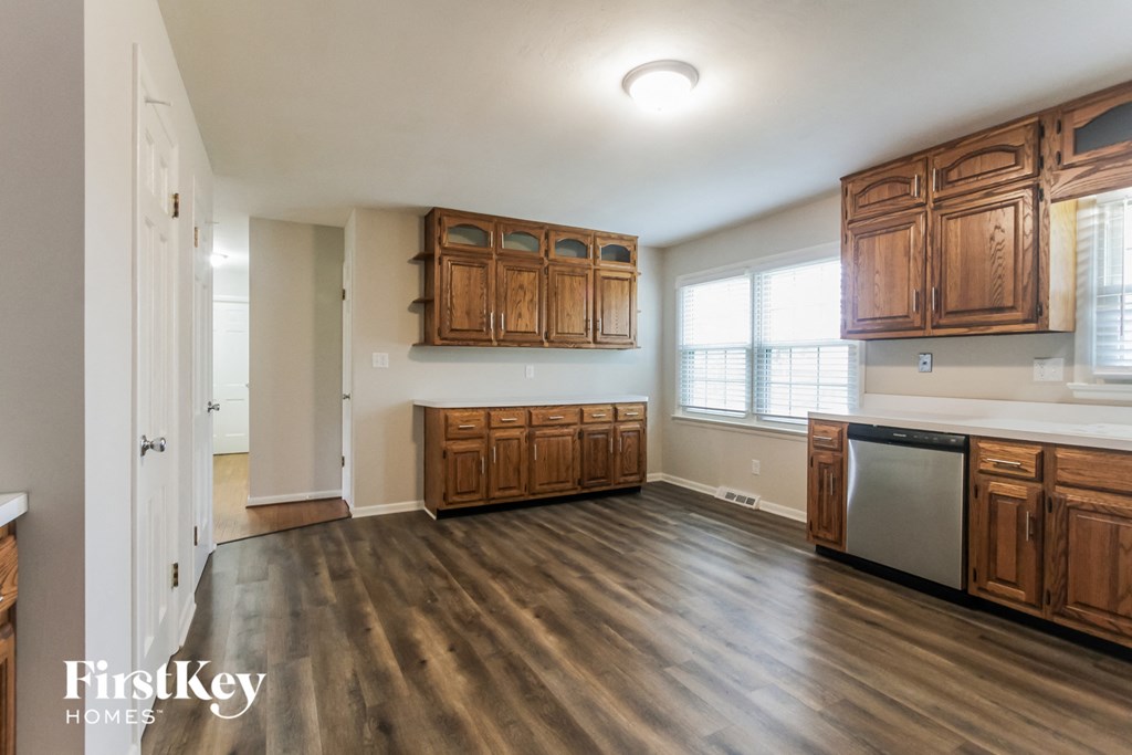 an empty kitchen with wooden cabinets and a large window