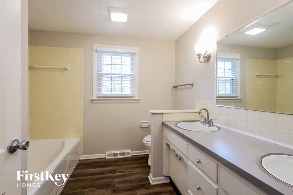 a bathroom with a tub and a sink and a mirror