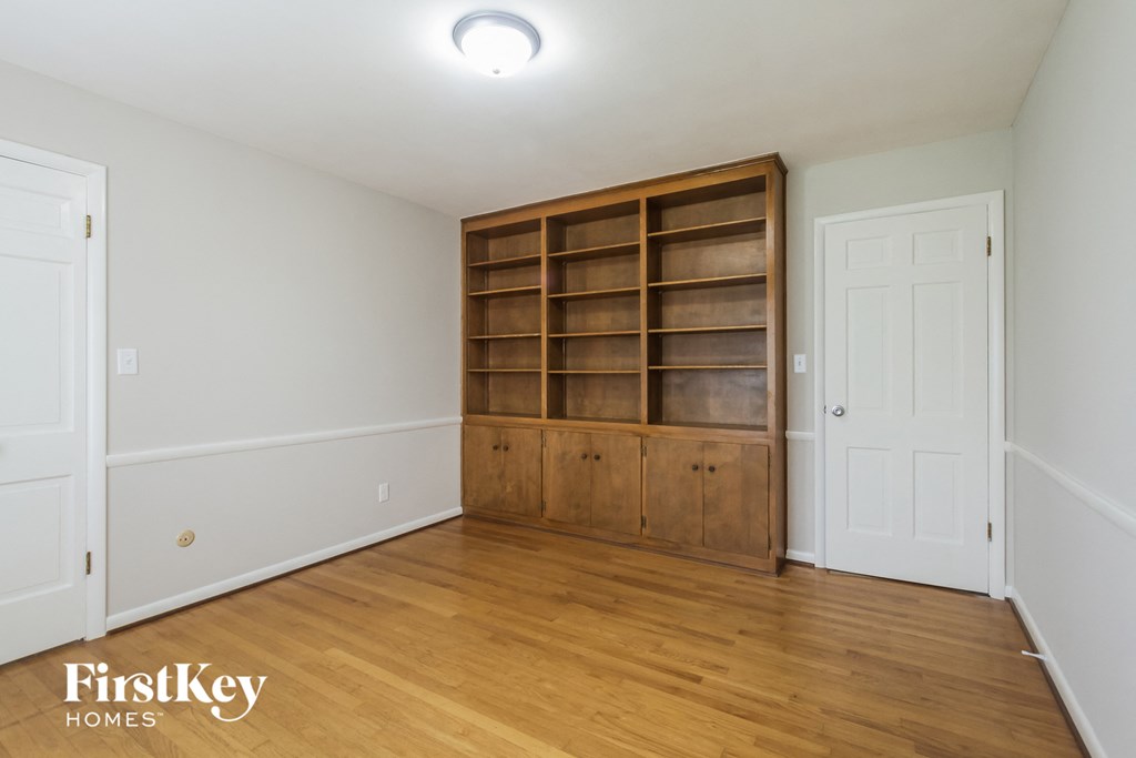 a bedroom with a bookshelf in the corner and a door to the closet