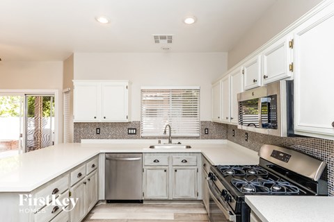 a kitchen with white cabinets and a stove and a sink