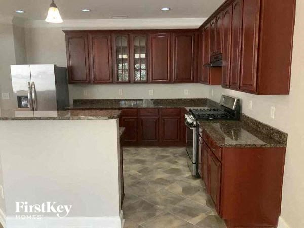 A kitchen with brown cabinets and a marble countertop.