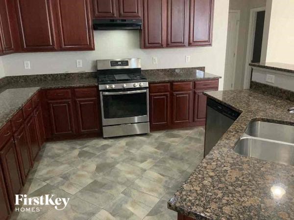 A kitchen with granite countertops and a stainless steel dishwasher.