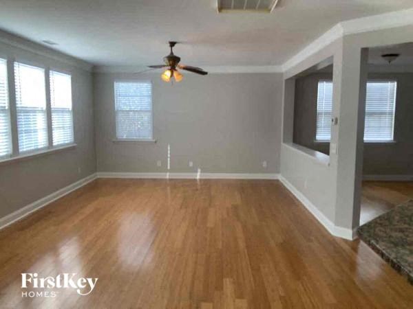 A room with wooden floors and a ceiling fan.
