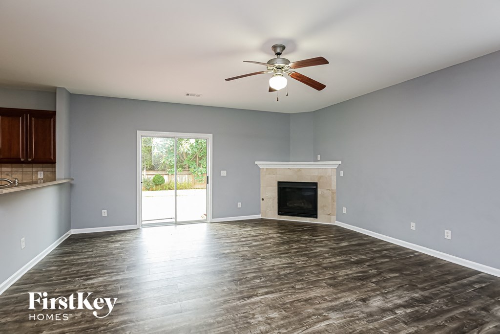 A spacious room with a fireplace and a ceiling fan.