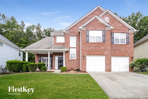 a brick house with two white garage doors