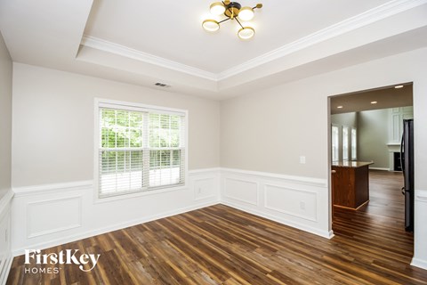 an empty living room with white walls and wood flooring