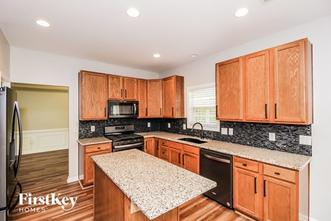 a kitchen with wooden cabinets and granite counter tops and black appliances