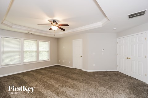 a living room with carpet and a ceiling fan