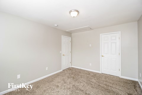 a bedroom with a carpeted floor and two white doors