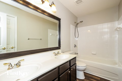 a bathroom with a sink and a mirror and a tub and a toilet