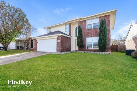 the front of a house with a lawn and a driveway