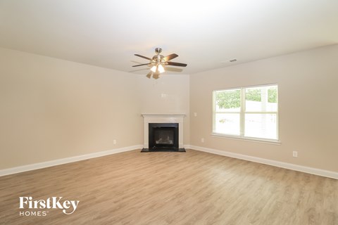 a living room with a fireplace and a ceiling fan