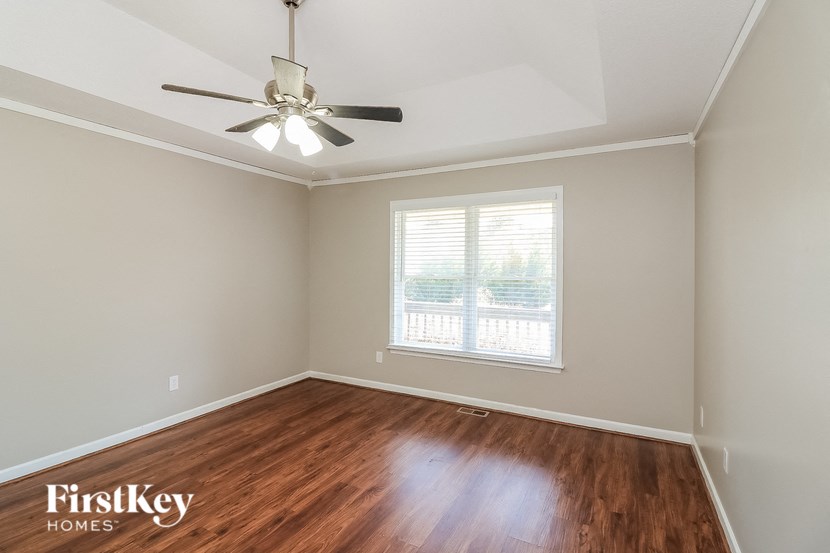 a bedroom with hardwood flooring and a ceiling fan
