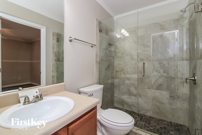 a bathroom with a shower toilet and sink and a mirror