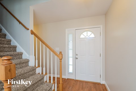 a white door with a window and stairs in a house