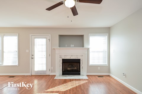 a living room with a fireplace and a ceiling fan
