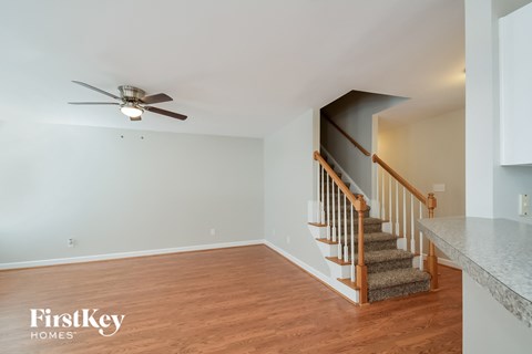 a living room with a staircase and a ceiling fan