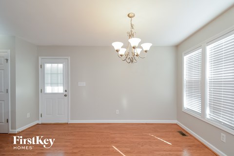 a dining room with a wood floor and a chandelier
