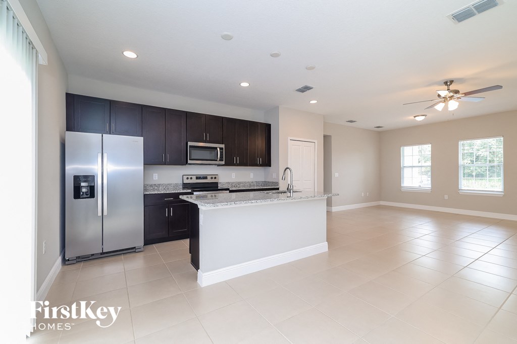A spacious kitchen with a refrigerator, microwave, oven, and a countertop.