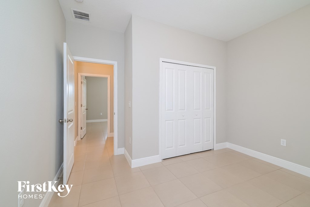 A white door is in a room with a tiled floor.
