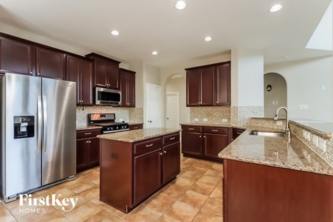 a large kitchen with stainless steel appliances and granite counter tops