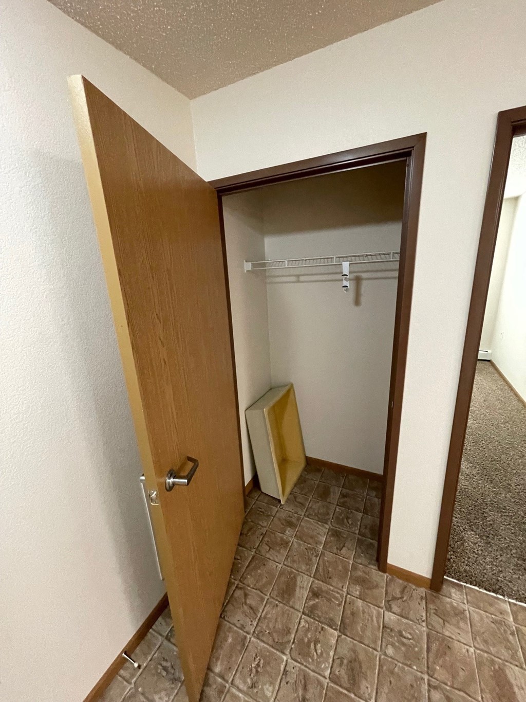 an empty bathroom with a door open to a closet