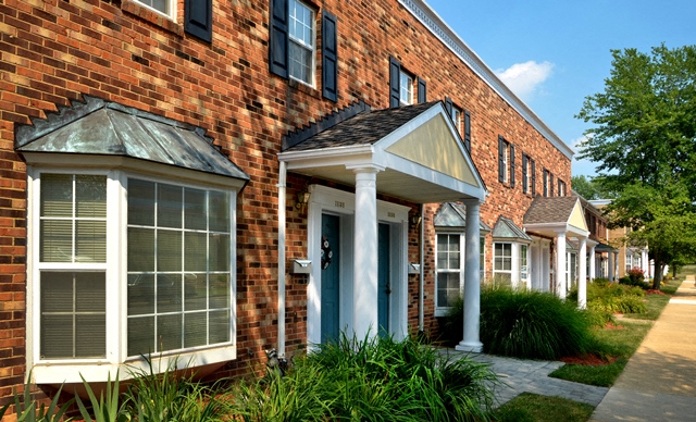 A row of houses with a brick facade and white trim.