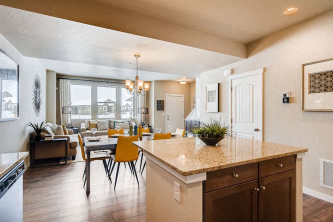 a kitchen and living room with a table and chairs
