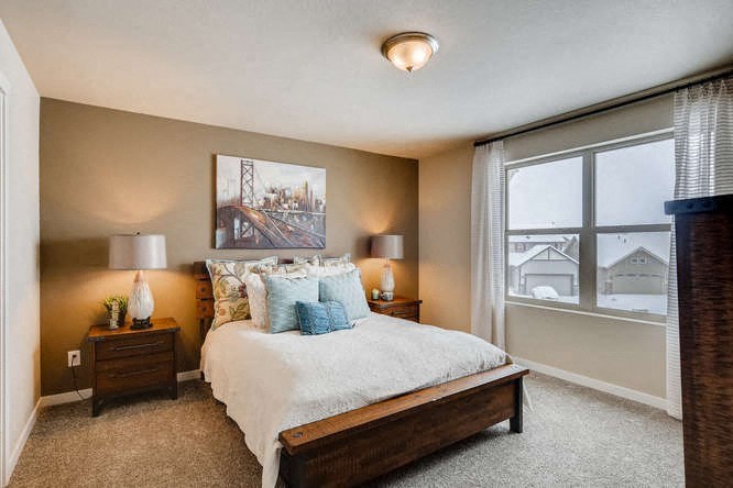 a bedroom with a bed and a large window