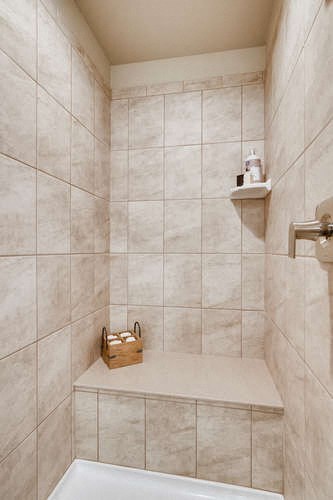 a tiled bathroom with a tub and a sink